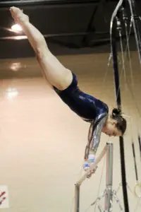 Gymnast performing 50 degree cast on xcel bars