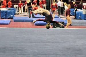 Gymnast doing front layout on Level 9 floor