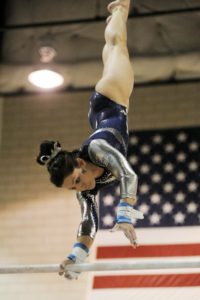 gymnast doing pirouette on Level 10 bars