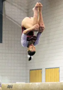 Gymnast doing back tuck in chalked up