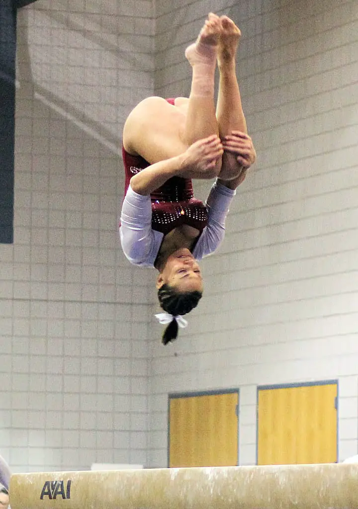 Gymnast doing back tuck in chalked up