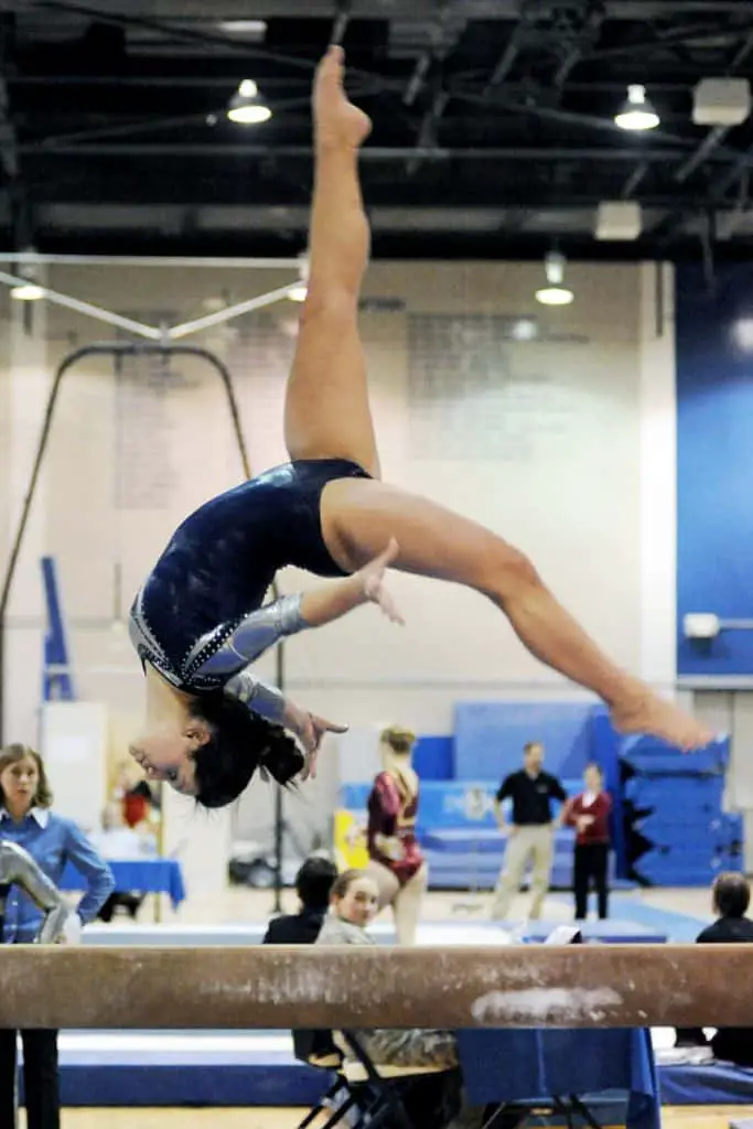 Gymnast doing acro series during Level 9 beam routine