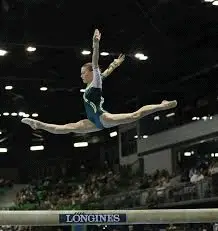 Gymnast doing leap in xcel diamond beam routine