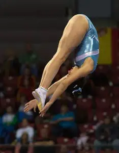 gymnast doing pike salto on xcel floor