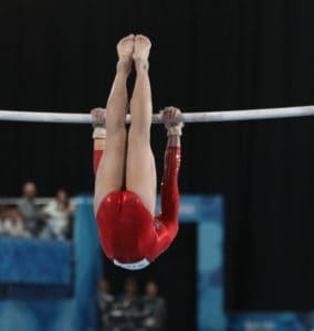 gymnast doing kip in Level 5 bar routine