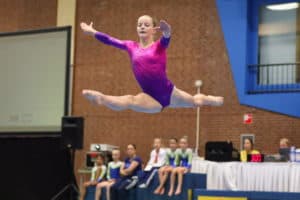 gymnast doing leap on Xcel bronze floor